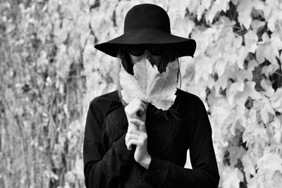 Portrait of woman holding fallen autumn leaves