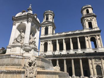 Low angle view of statues on building against sky