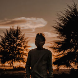 Side view of man standing against sky during sunset