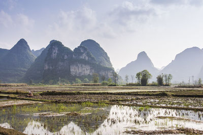 Scenic view of lake by mountains against sky