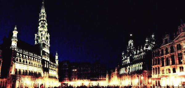 Low angle view of illuminated buildings against clear sky