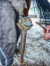 Low section of man working on metal structure