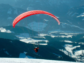 Person paragliding over mountain