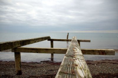 Wooden pier on sea against sky