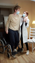 Young man with woman standing on floor at home