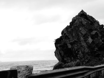 Close-up of rock by sea against sky