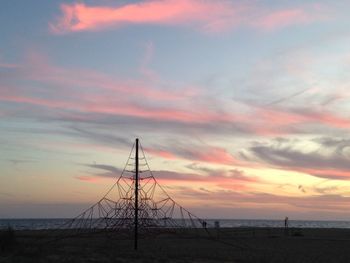 Silhouette of electricity pylon at sunset