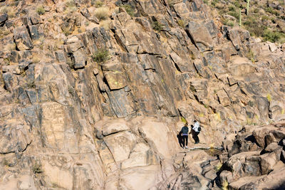 Full length of women climbing on rock