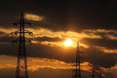High section of electricity pylons against sunset