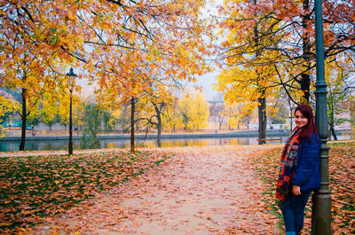 Woman standing by trees during autumn