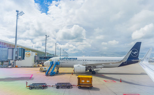 Airplane on airport runway against sky