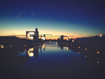 Silhouette of bridge over river at dusk