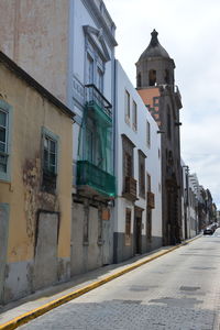 Street amidst buildings against sky in city