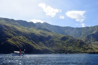 Scenic view of river by mountains against sky