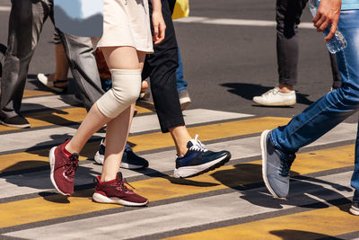 Low section of people walking on crosswalk