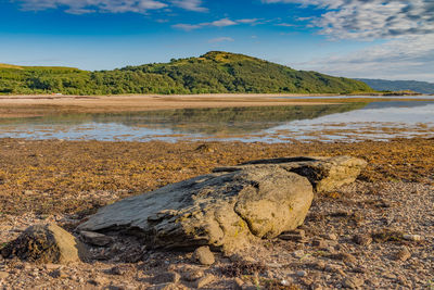 Scenic view of rocks on beach against sky