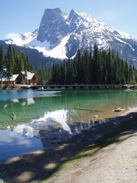 Scenic view of lake by snowcapped mountains against sky