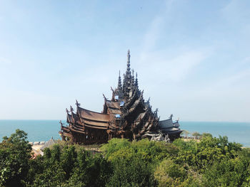 Traditional building by sea against sky