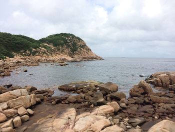 Rocks by sea against sky