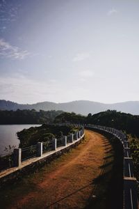 Bridge over calm sea against sky