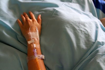 Patient's hands giving the saline solution on bed with copy space. healthy, medicine or medical