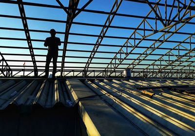 Man standing below metallic roof