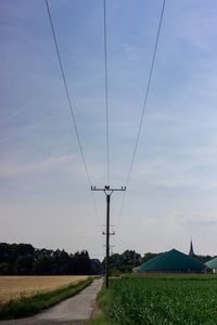 Electricity pylon on field against sky