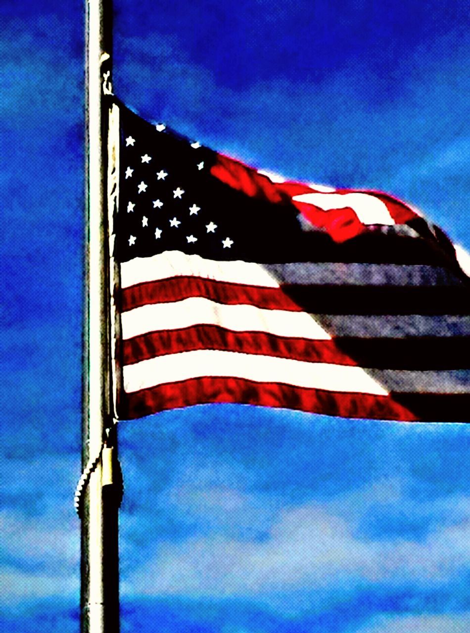 LOW ANGLE VIEW OF AMERICAN FLAG AGAINST SKY