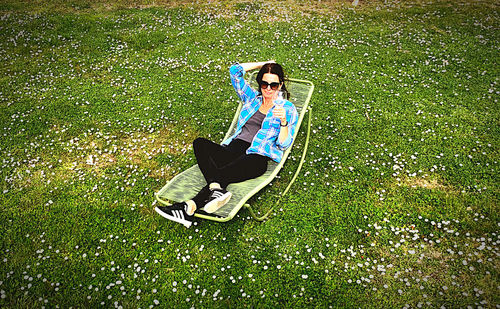 High angle view of young woman relaxing on field