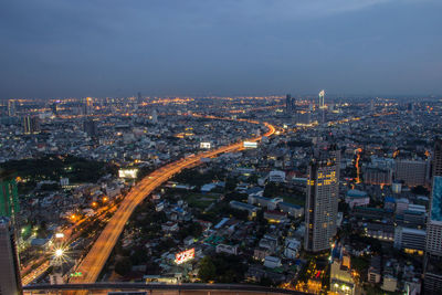 High angle view of illuminated cityscape against sky at night