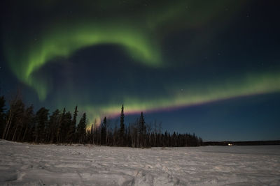 Breathtaking green dancing aurora borealis in the dark sky in sirkka, lapland, northern finland.