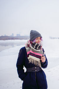 Full length of girl standing on snow covered landscape against sky