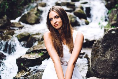 Portrait of young woman standing on rock