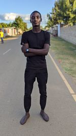 Portrait of young man standing on road