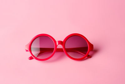 Close-up of sunglasses against pink background