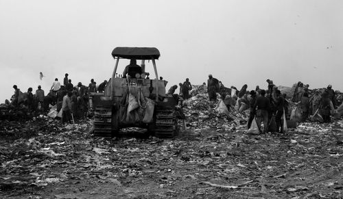 Bulldozer seen at landfill site. people collect belongings from the garbage to survive livehood