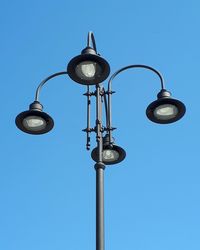 Low angle view of street light against blue sky