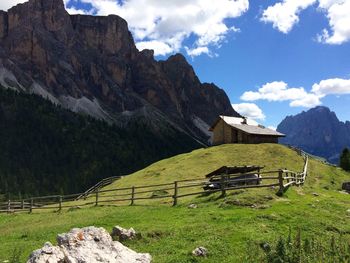 Scenic view of grass field and mountains during sunny day