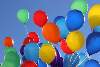 Low angle view of multi colored balloons against clear sky