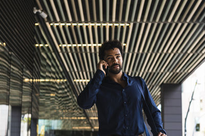 Full length of young man standing against ceiling