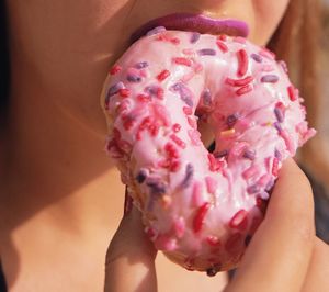Midsection of woman holding pink cake
