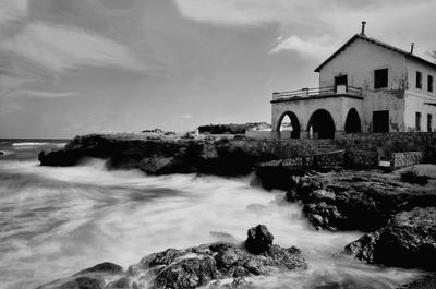 Scenic view of sea by buildings against sky