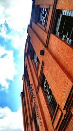 Low angle view of buildings against blue sky and clouds