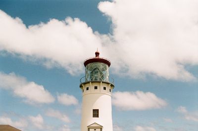 Low angle view of lighthouse by building against sky