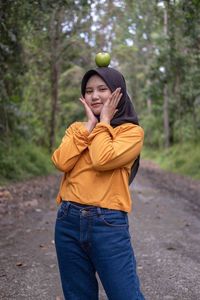 Portrait of young woman standing in forest