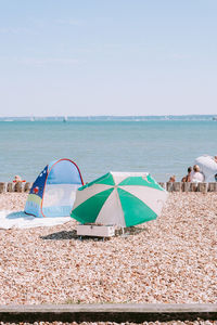 People at beach against clear sky