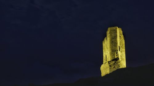 Low angle view of illuminated building against sky at night