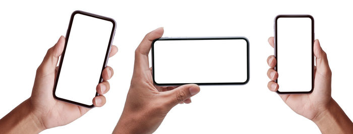 Low section of person holding smart phone against white background