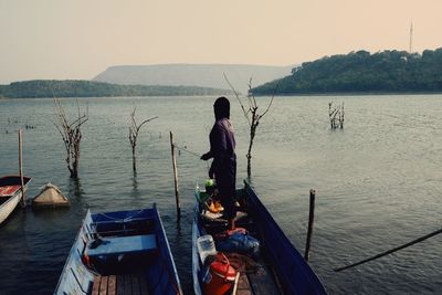 Rear view of man standing on sea against sky