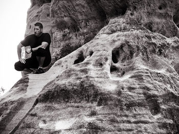 Low angle view of man standing on rock